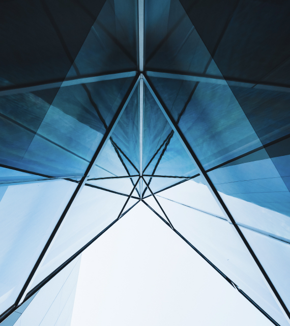Modern glass facade with intersecting lines and triangular reflections