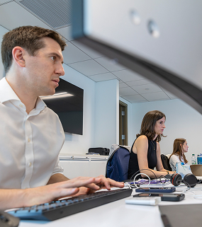Team members working at desks in a modern office environment
